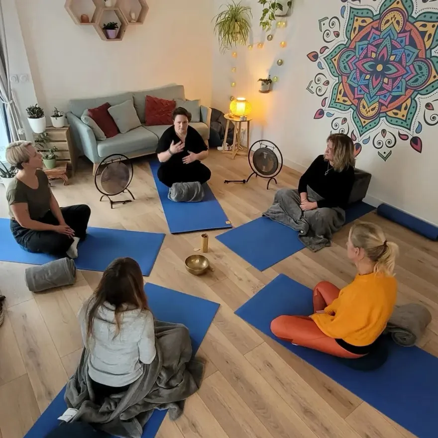 Une séance de sophrologie en groupe au cabinet : le cercle réuni sur les tapis, devant le mandala